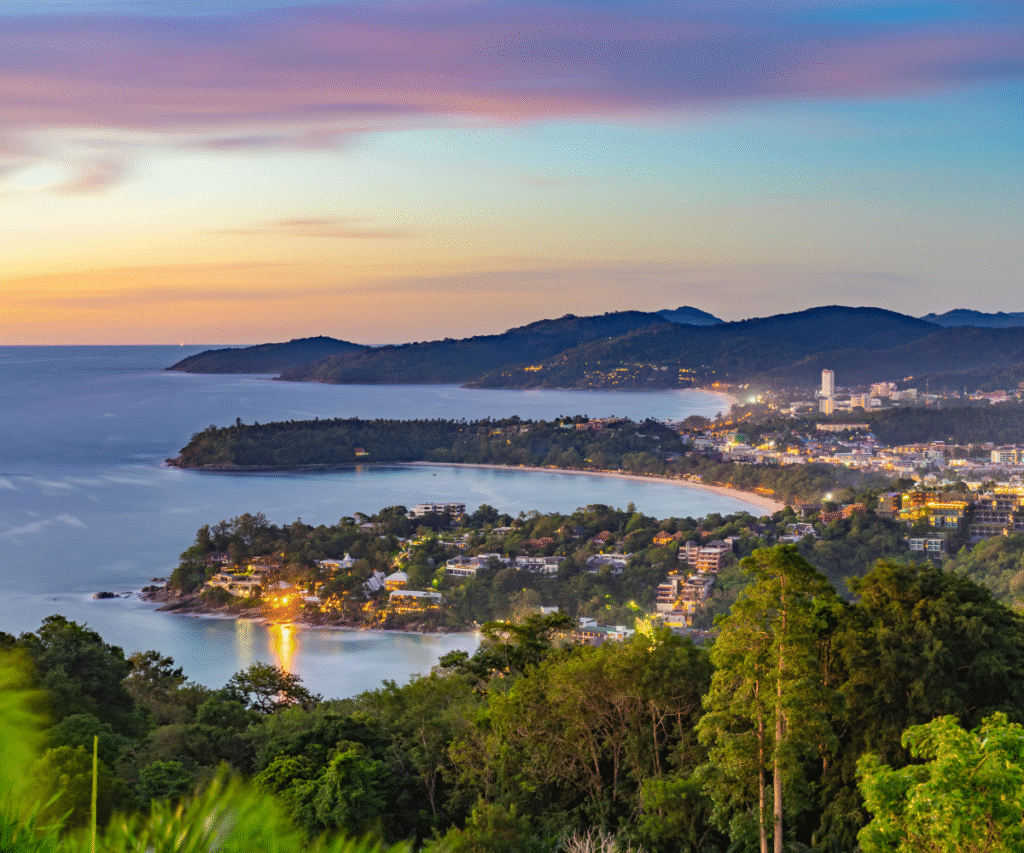 Evening view of Phuket coastline with rolling hills and glowing shoreline