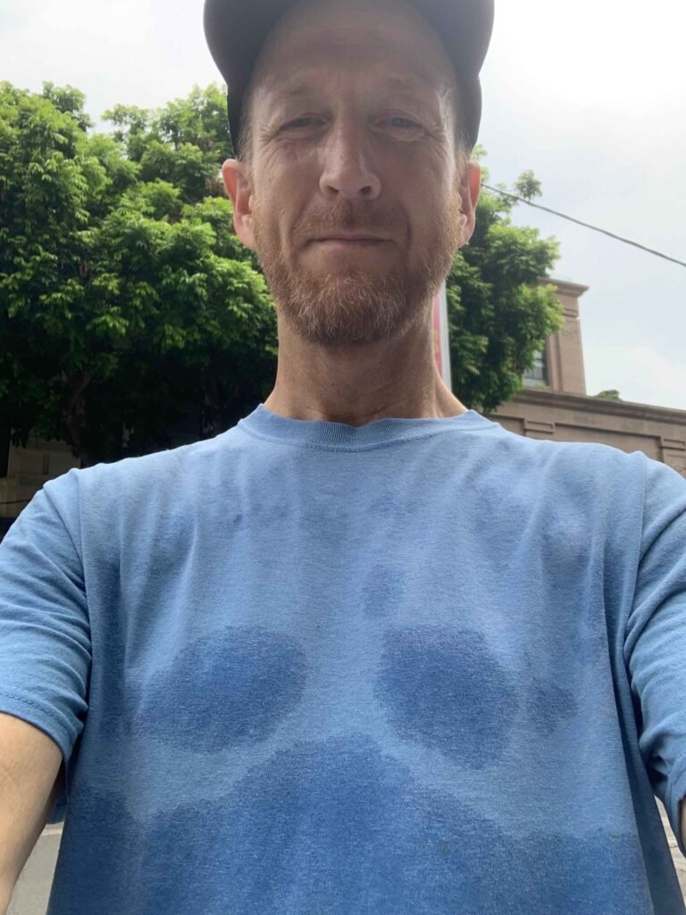 Traveler in blue shirt soaked with sweat from Hanoi humidity