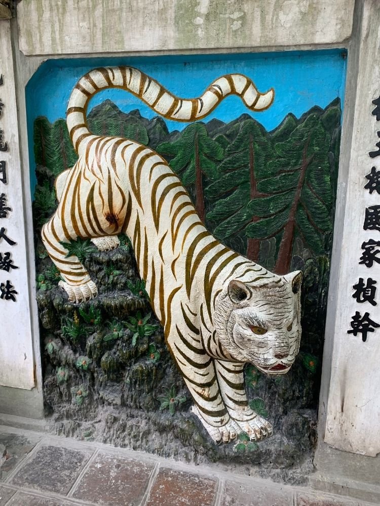 Colorful tiger carving on temple wall in Hanoi