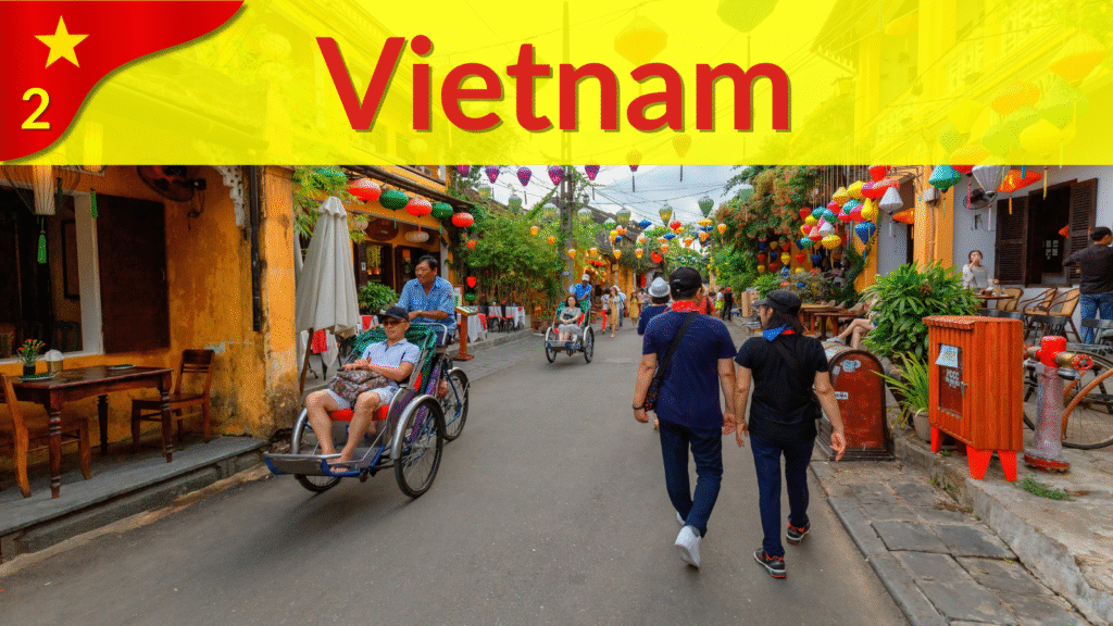 Colorful lanterns hanging above a walking street in Hoi An Old Town, Vietnam, with people riding cyclos and strolling past cafes.