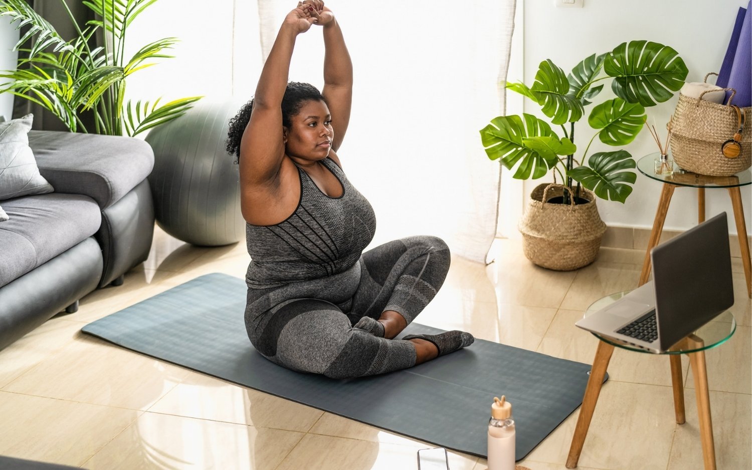 continuing-education-yoga-teachers-home-study Woman practicing yoga at home during an online continuing education course for yoga teachers