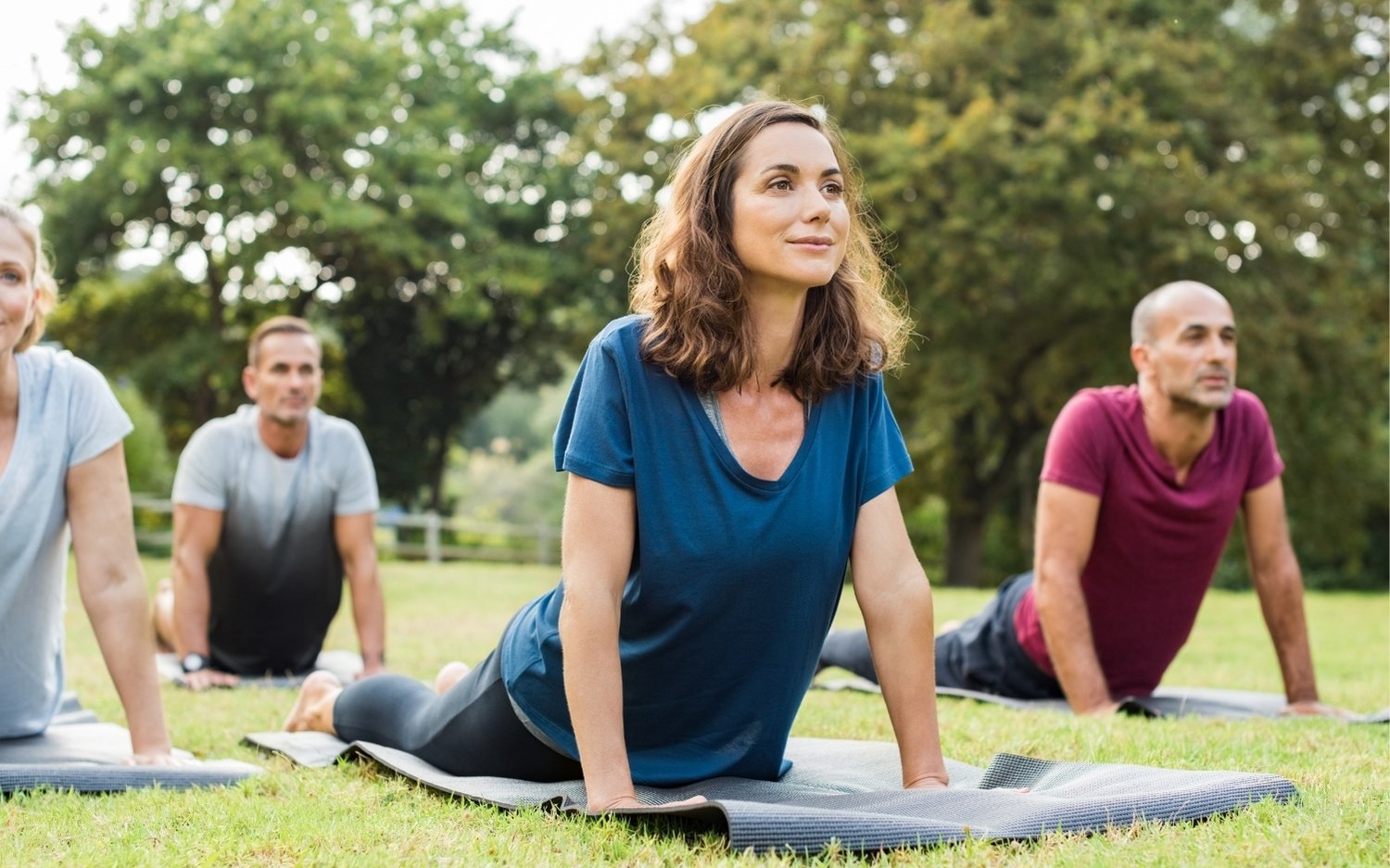 outdoor-yoga-class-post-ytt Small yoga group practicing upward-facing dog outdoors
