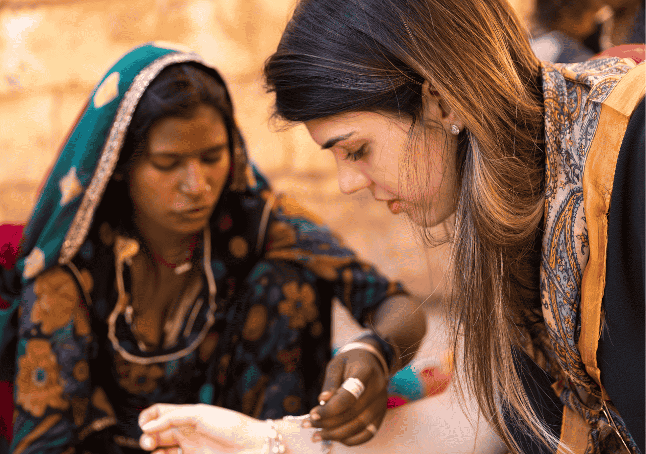 womens-safety-india-local-connection Western female traveler interacting with local woman in India, highlighting cultural connection and women’s safety awareness