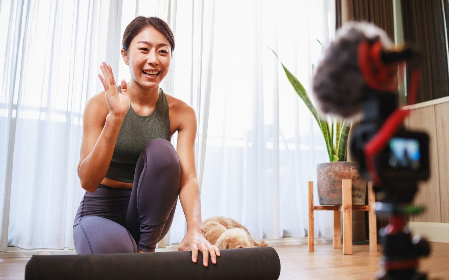 yoga-teacher-online-class-first-year Smiling yoga teacher filming an online class at home