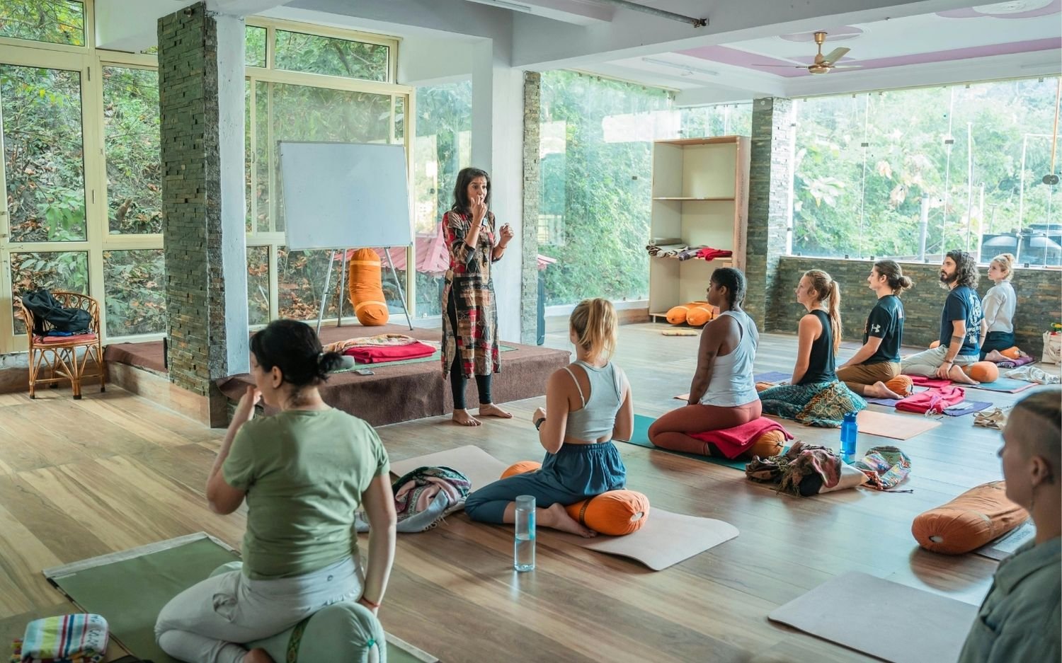 yoga-teacher-training-philosophy-and-breathwork-class Yoga teacher leading a seated group in pranayama during teacher training
