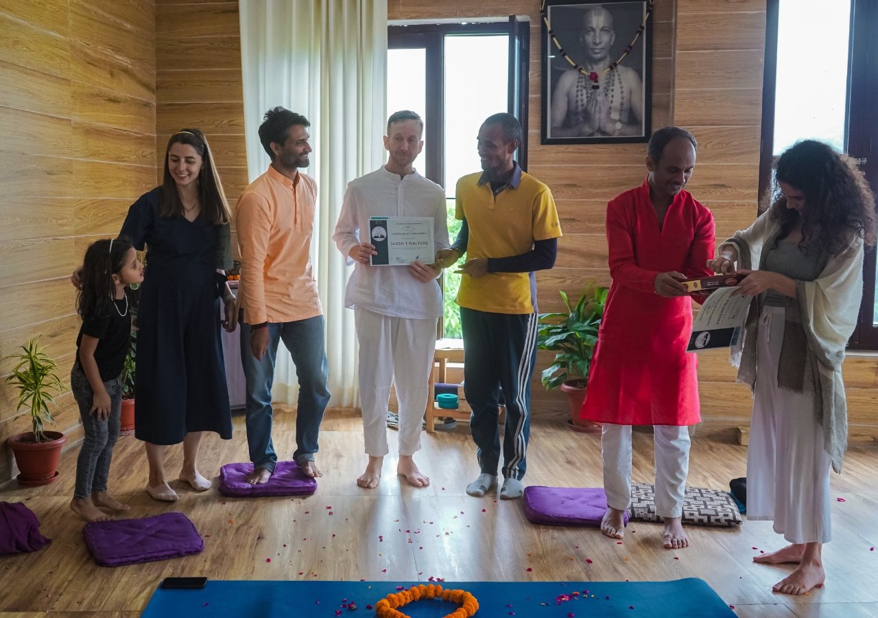 advanced-yoga-certification-graduation Group of yoga teachers celebrating advanced certification with certificates in a yoga studio.