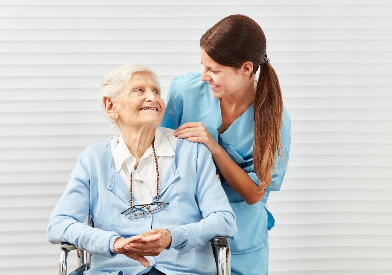 Older woman sitting on a chair with eyes closed and hands together in prayer position