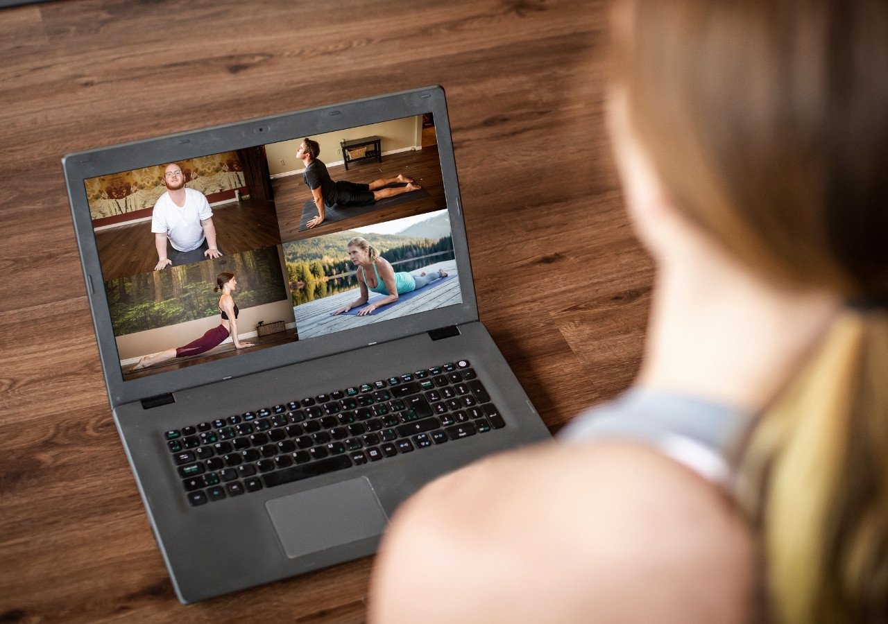 Laptop screen showing multiple people in an online yoga session
